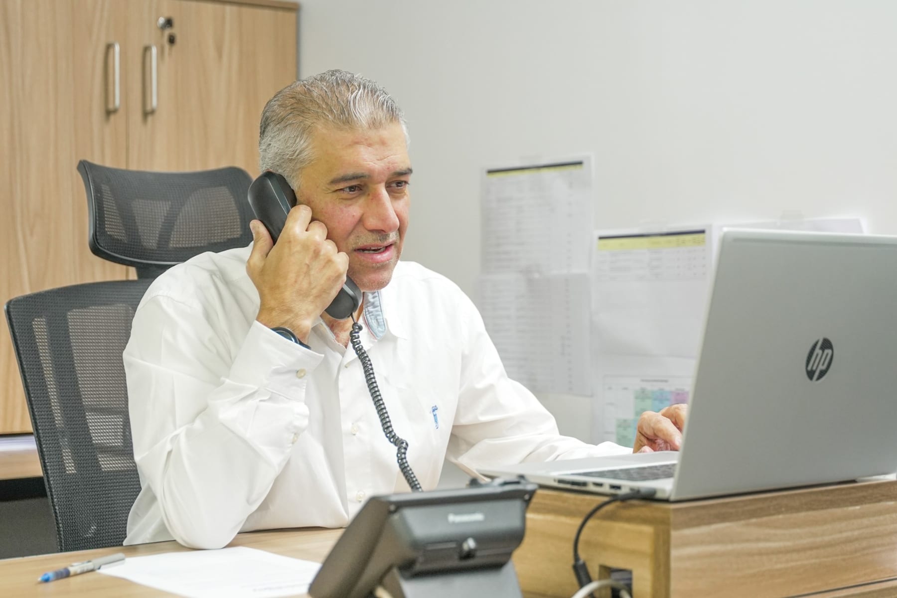 A manager on the phone at his desk