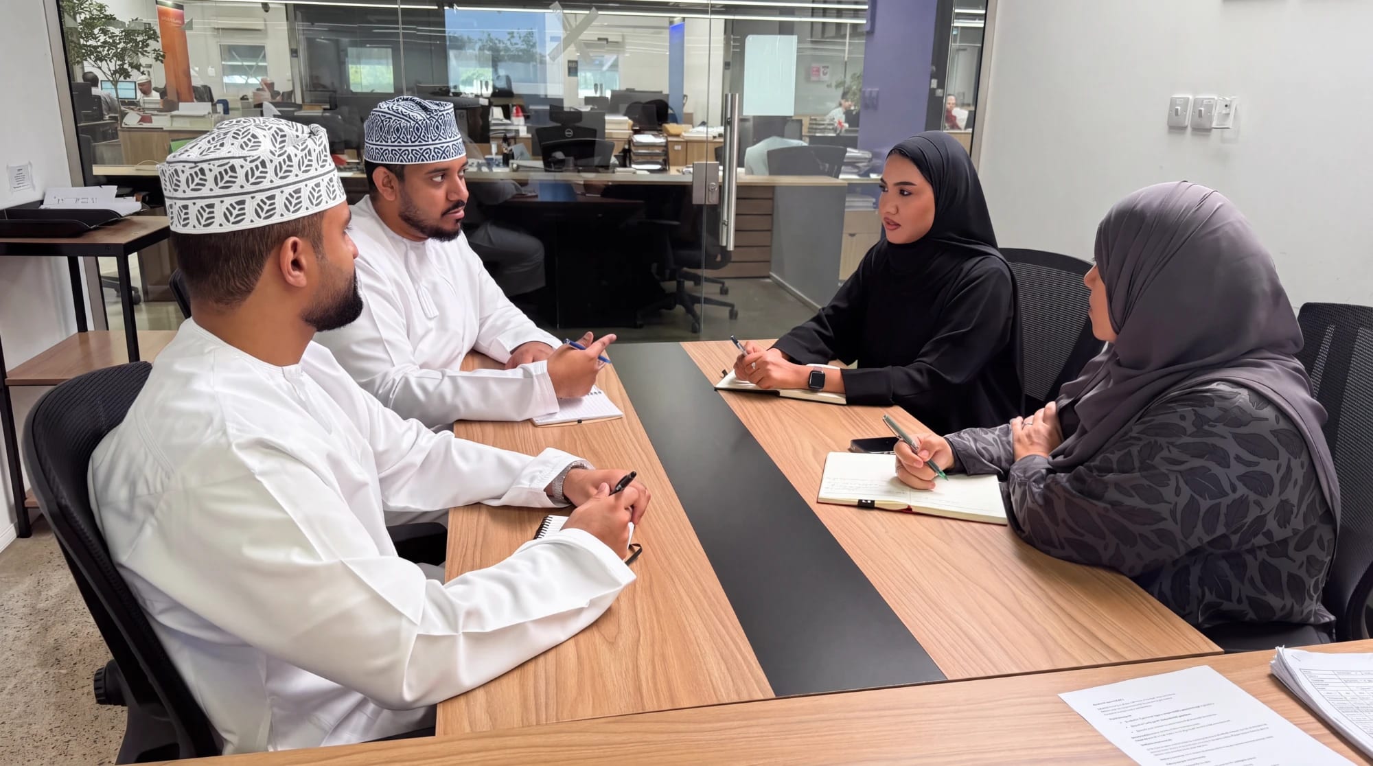 Four colleagues in discussion around a meeting table